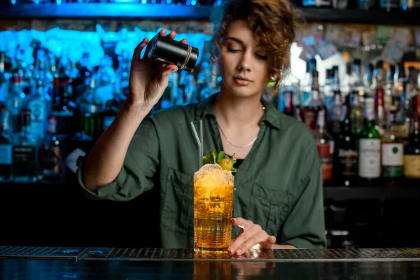 Mladá žena barman začne zdobit práškové sklo s koktejlem. — Stock fotografie