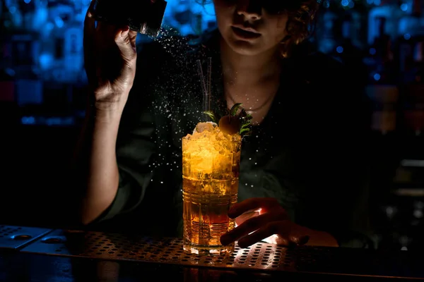 Mujer camarera en la barra oscura decorar con vidrio en polvo con cóctel . — Foto de Stock