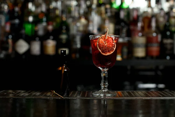 Close-up van glas met kant-en-klare cocktail, versierd met schijfje citrus op de bar. — Stockfoto