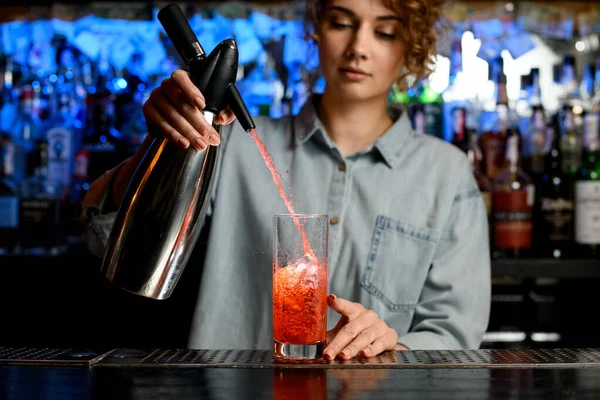 Genç barmen kadın profesyonel olarak çelik sifon kullanarak kokteyl dolduruyor. — Stok fotoğraf