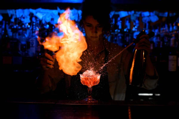 Бармен мастерски наливает коктейль из стального сифона в стекло на барную стойку . — стоковое фото