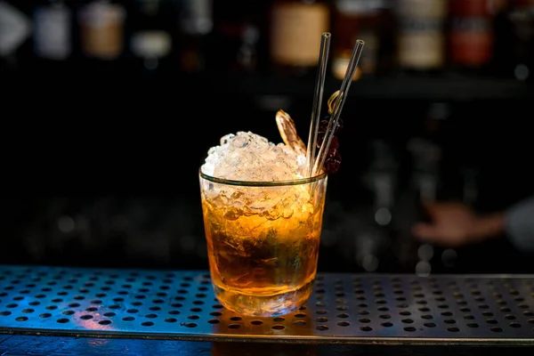 Крупный план яркий алкогольный коктейль с кусочками льда, как негрони на баре . — стоковое фото