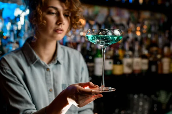Fiatal csinos nő csapos kezében gyönyörű pohár kék koktél, és nézd meg. — Stock Fotó