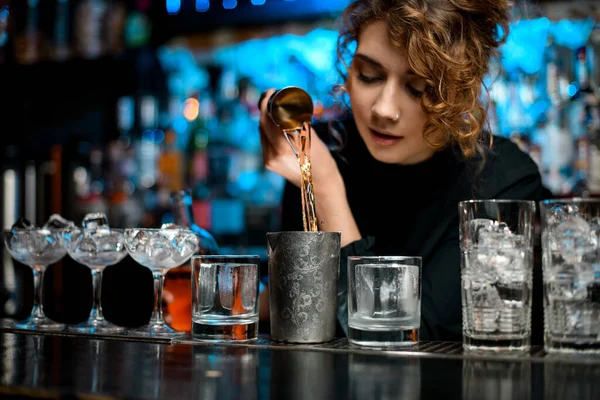 Barman woman masterfully pours drink into metal glass to make negroni coctail. — Stock Photo, Image