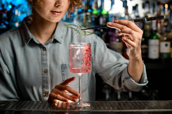 Jovem bartender mulher precisa decora vidro com coquetel por pedaço de planta verde . — Fotografia de Stock