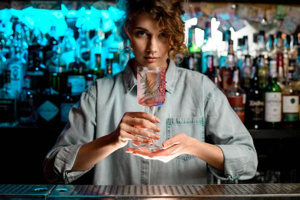 Красивая бармен осторожно держит стекло в руках . — стоковое фото