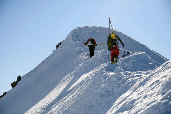 Snowboardista a lyžař stoupá na vrchol hory — Stock fotografie