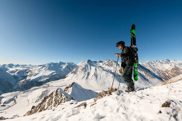 Человек с лыжным снаряжением стоит на горе — стоковое фото
