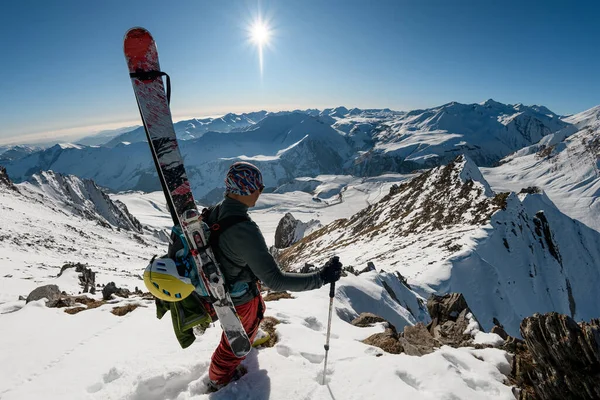 Viajando homem com equipamento de esqui em montanhas nevadas . — Fotografia de Stock