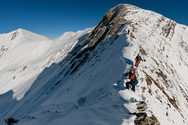 Deux athlètes se préparent pour la descente de la montagne enneigée en pierre . — Photo