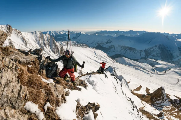 Mannen klimmen naar de top van de besneeuwde berg op zonnige dag — Stockfoto