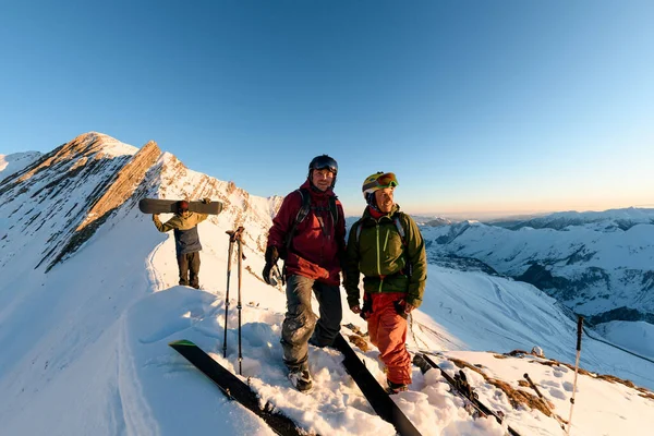 Grupp av friåkare snowboardåkare och skidåkare högt uppe i bergen — Stockfoto