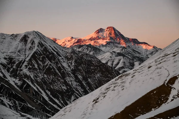 Raios de sol no pico da montanha nevada . — Fotografia de Stock