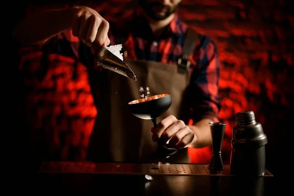 Primo piano barista versando pezzi di ghiaccio in bicchiere da vino nero . — Foto Stock