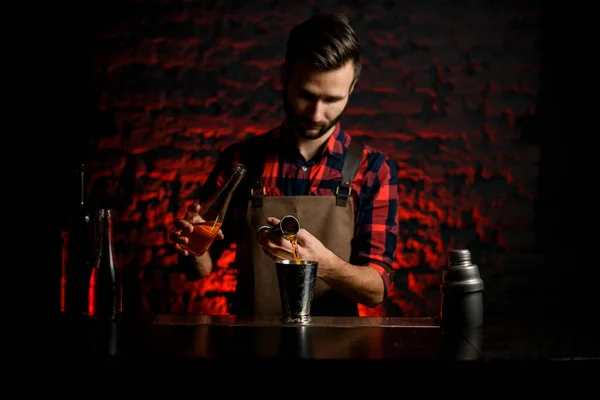 Man bartender pours cocktail from bowl into metal martini glass. — Stock Photo, Image