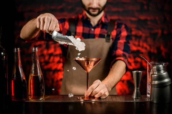 Barista mano versando pezzi di ghiaccio in vetro Martini metallo . — Foto Stock