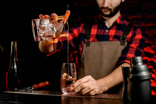 Hombre en el bar vierte suavemente cóctel alcohólico frío r en vidrio —  Fotos de Stock