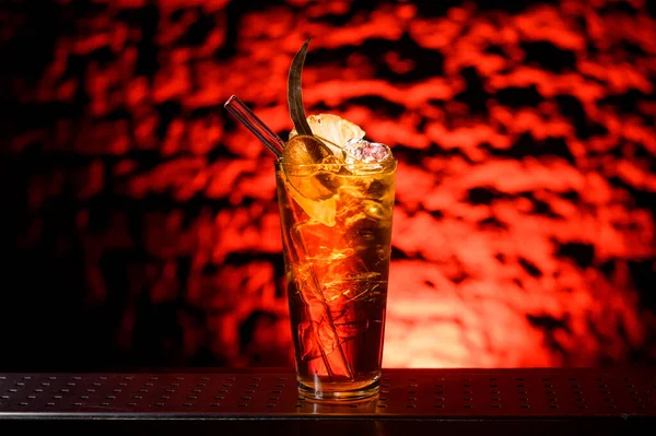 Gros plan de verre avec cocktail alcoolisé lumineux décoré de tranches d'agrumes — Photo