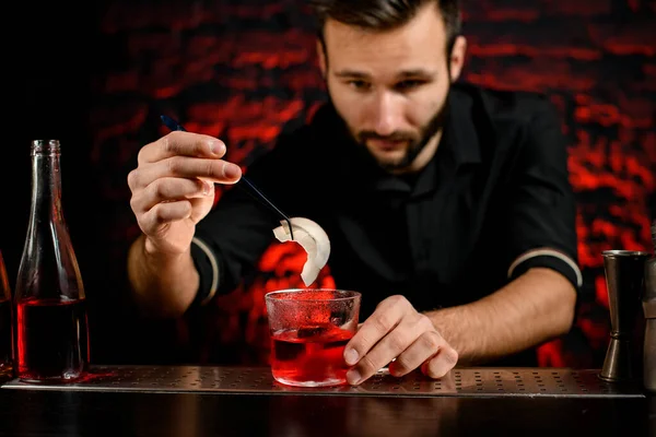 Barista professionista decora bicchiere da cocktail con due pezzi di cocco — Foto Stock