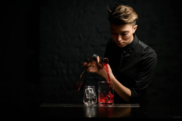 Female bartender masterfully pours alcoholic drink into mixing cup. — Stock Photo, Image