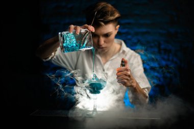 Kadın barmen, Smoky Bar 'da bardağa karıştırırken mavi kokteyl döküyor ve şuna bak.