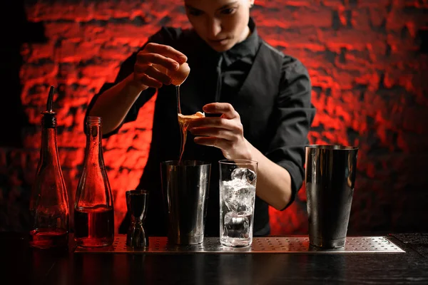 Bartender em roupas pretas segurando ovo quebrado em suas mãos sobre agitador de aço . — Fotografia de Stock