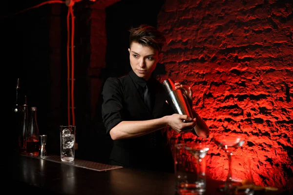 Profissional bartender segurando agitador de aço em suas mãos e misturá-lo — Fotografia de Stock