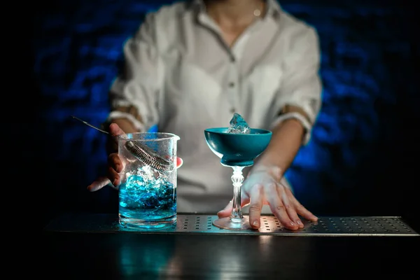 Camareros manos en el vidrio azul y la taza de mezcla con el soporte de cóctel frío azul en el mostrador de bar —  Fotos de Stock