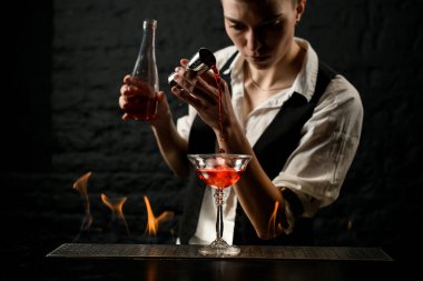 Barmen profesyonel olarak barın üzerinde duran bardağa su doldurur.