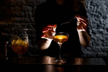 Barmen bardağı hazır kokteyl dutlarıyla süslüyor.