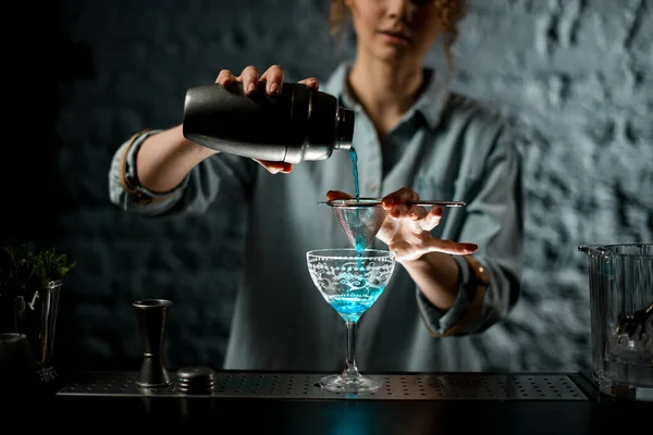 Professionale barista donna versa finito cocktail blu a vetro . — Foto Stock