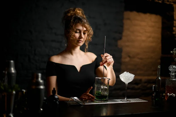 Beleza jovem bartender misturado coquetel por colher de bar longo . — Fotografia de Stock