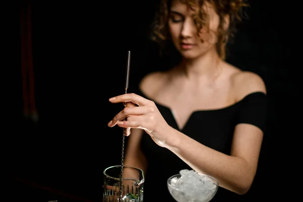 Primer plano. Belleza joven camarera suavemente mezclado cóctel por cuchara de bar largo . — Foto de Stock