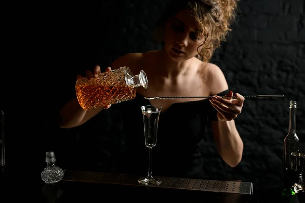 Молодая привлекательная сексуальная девушка в баре наливает напиток в стекло — стоковое фото