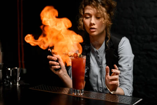 Barista ragazza spruzza su vetro con cocktail e dà fuoco . — Foto Stock