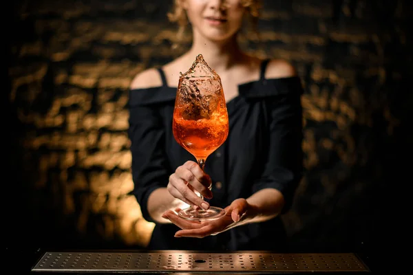 Glass of ready-made negroni cocktail holds woman at bar. — Stock Photo, Image