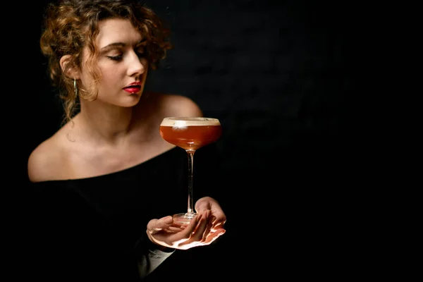 Belle et attrayante jeune femme tient verre avec cocktail aigre . — Photo
