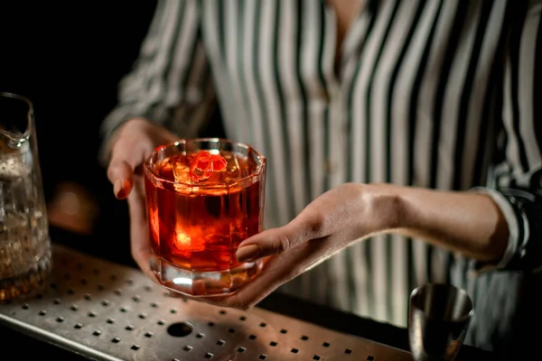 Close-up view on old-fashioned glass with cocktail in woman hands at bar — Stock Photo, Image