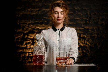 Kristal sürahi, içki ve cam barın üstünde duruyor..