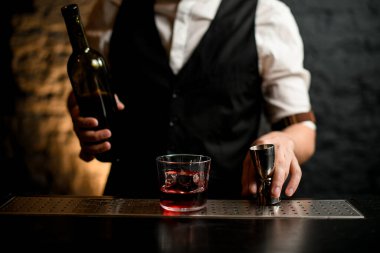 Barmen barın tezgahında duran çeliği tutuyor..