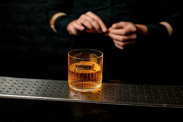 Крупный план старомодный стакан с янтарным алкогольным напитком, стоящим у барной стойки . — стоковое фото
