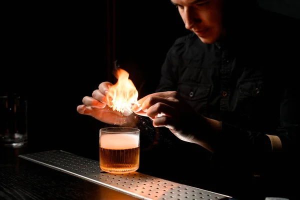 Barista professionista fa fuoco su vetro con cocktail alcolici e guardalo — Foto Stock