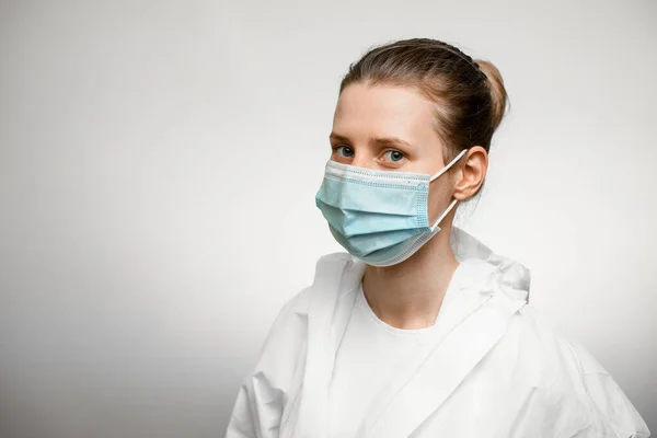 Молодая женщина врач в защитном костюме и медицинской маске . — стоковое фото