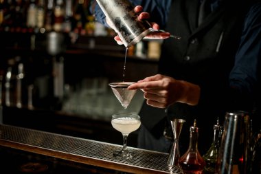 Barmen bardaktan bardağa doldurur.