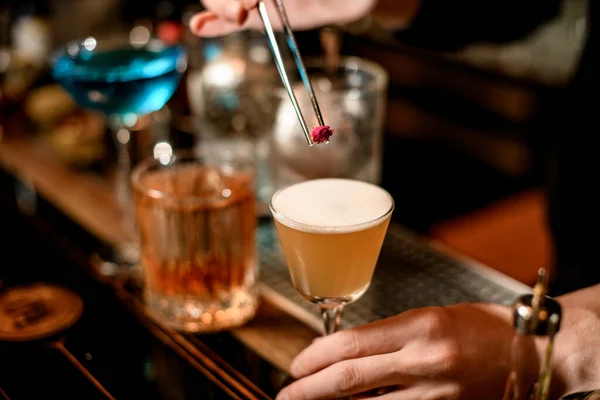 Primo piano. Barman decorare bicchiere da cocktail acido con poco rosa — Foto Stock
