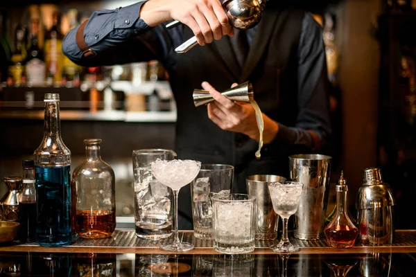 Bartendern häller pressad juice från jigger i shaker — Stockfoto