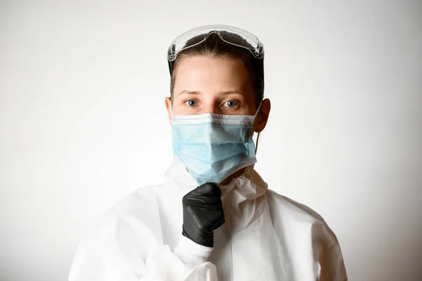 Όμορφη νεαρή γυναίκα ρυθμίζει ιατρική μάσκα στο πρόσωπό της — Φωτογραφία Αρχείου
