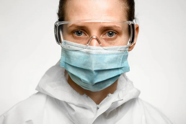 Femme aux yeux bleus avec masque médical et lunettes de protection contre la grippe . — Photo