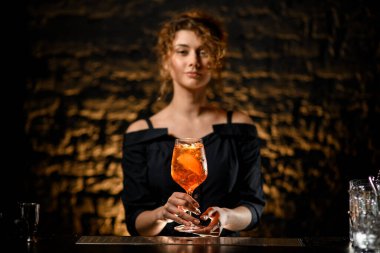Bardaki çekici genç kadın bardağında kokteyl tutuyor.