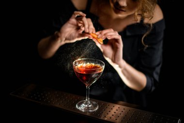 Kadın barmen nazikçe narenciye suyunu bardağa döküyor..